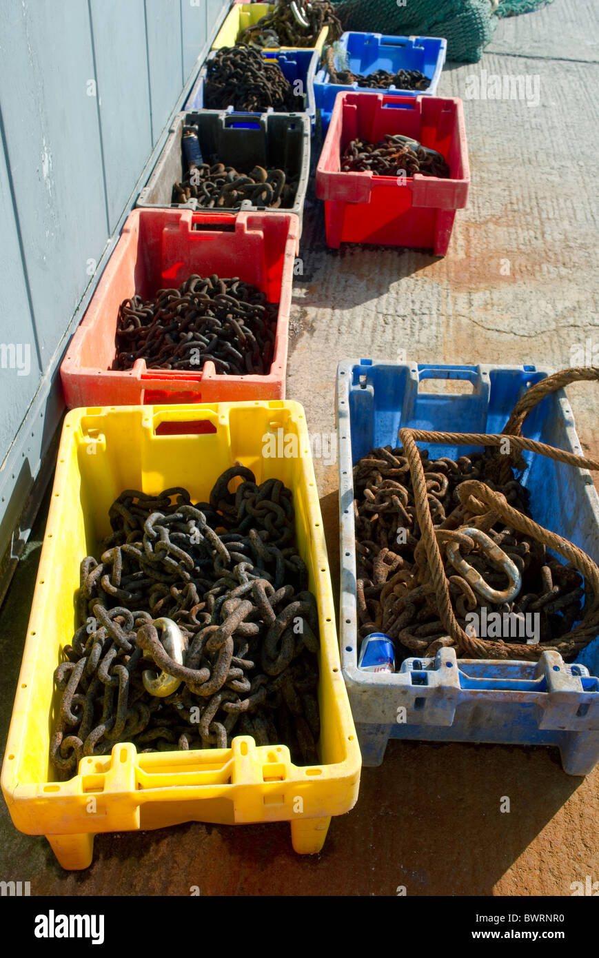 Fish boxes full of rusting chains and other iron on the quay at Skerries, north County Dublin, Ireland Stock Photo