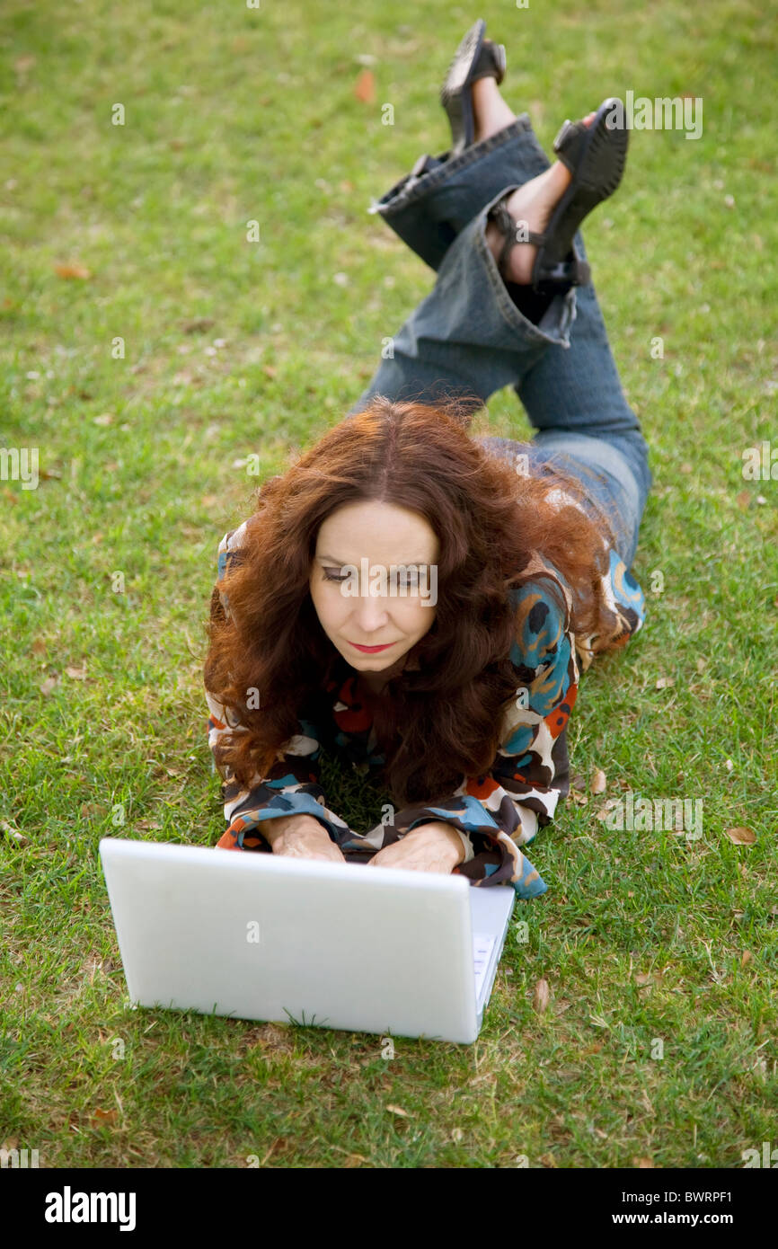 Woman working on her laptop in a park Stock Photo - Alamy