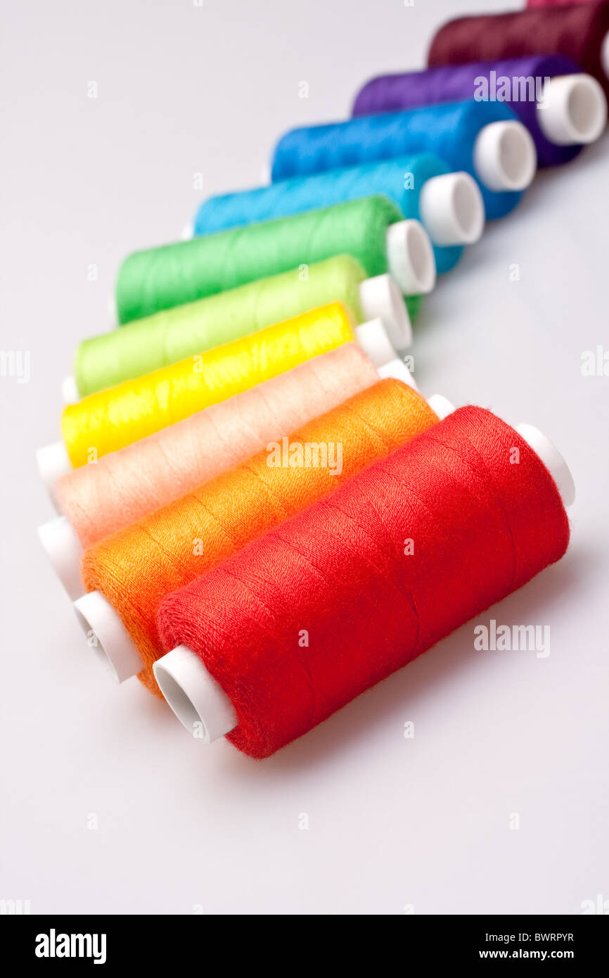 multi-colored rainbow threads for sewing with needle and thimble, Stock  image