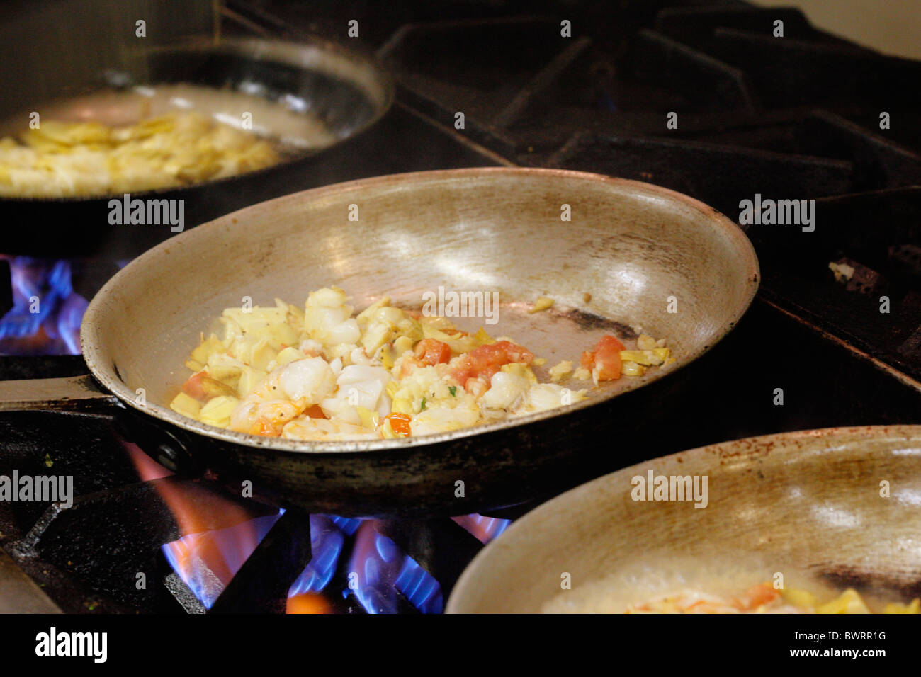 Saute pans cooking in the kitchen of an Italian restaurant in the USA. Stock Photo