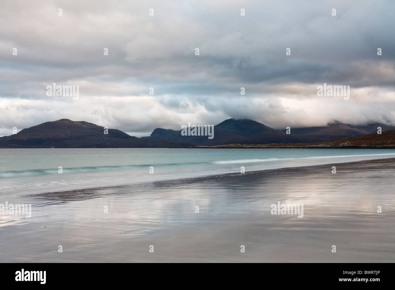 Storm clouds gather over the Harris hills seen from across the sound of Taransay on traigh Rosamol on the isle of Harris. Stock Photo