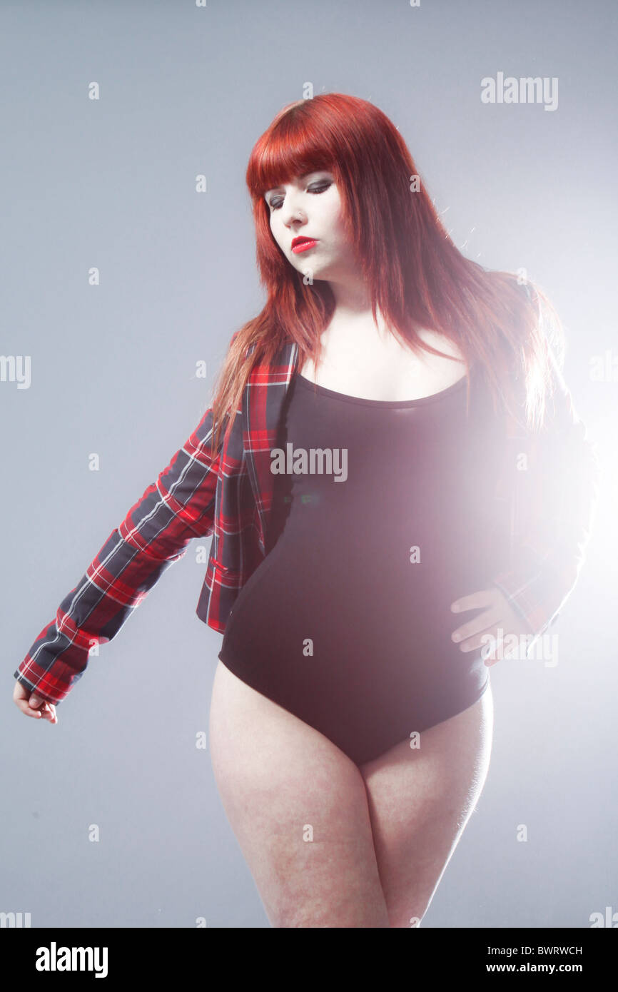 Fashion portrait of a young redhead model wearing a tartan jacket and leotard. Stock Photo