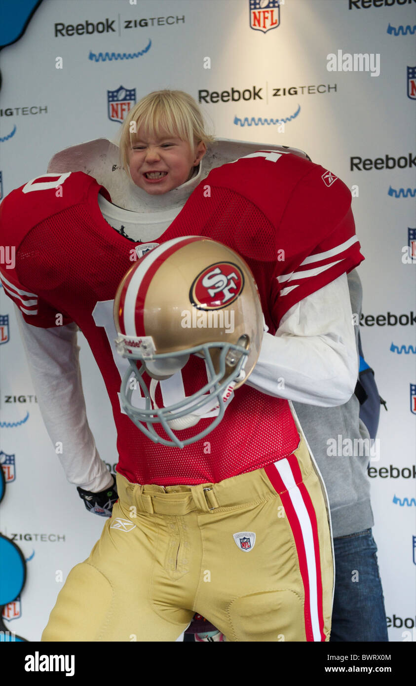 A young girl poses for a portrait in a San Francisco 49er football uniform during the NFL rally at Trafalgar Square, London on Stock Photo