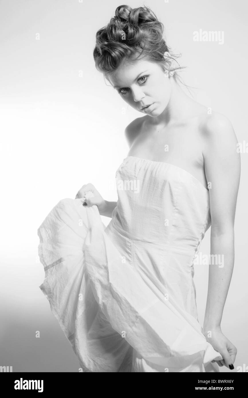 Black and white fashion portrait of a young model in a white dress ...