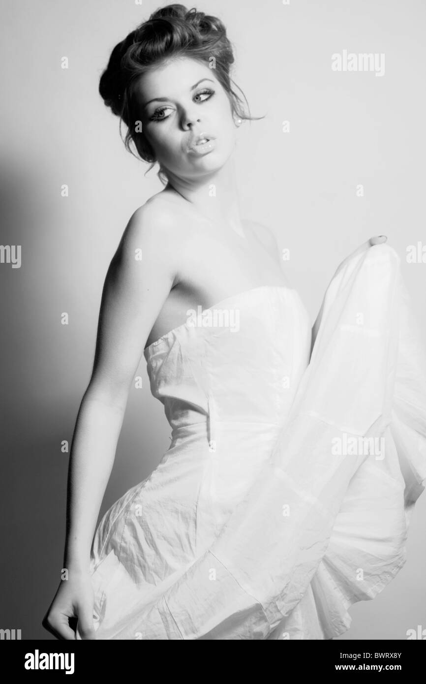 Black and white fashion portrait of a young model in a white dress ...
