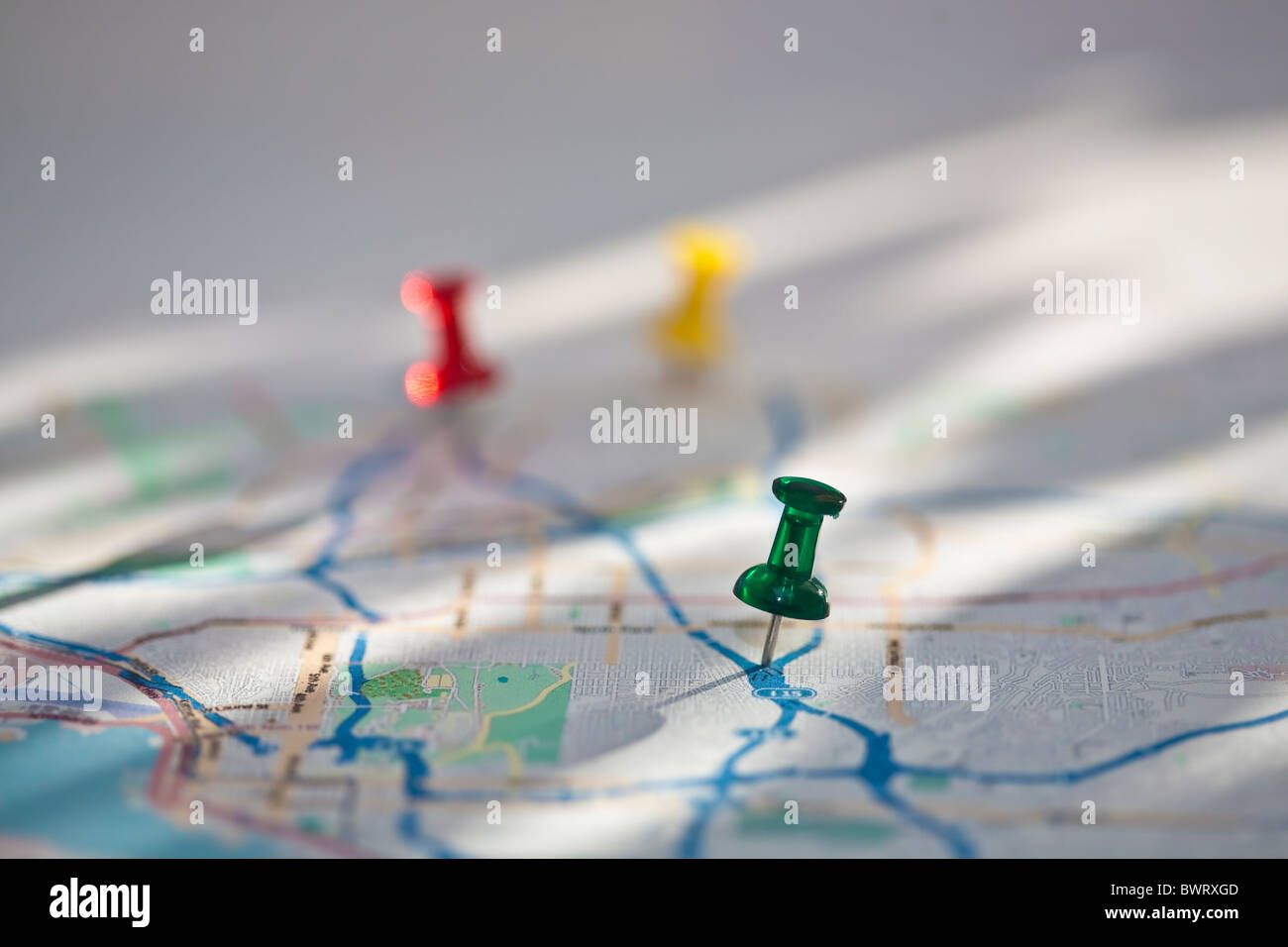 colored push-pins in colorful paper map Stock Photo