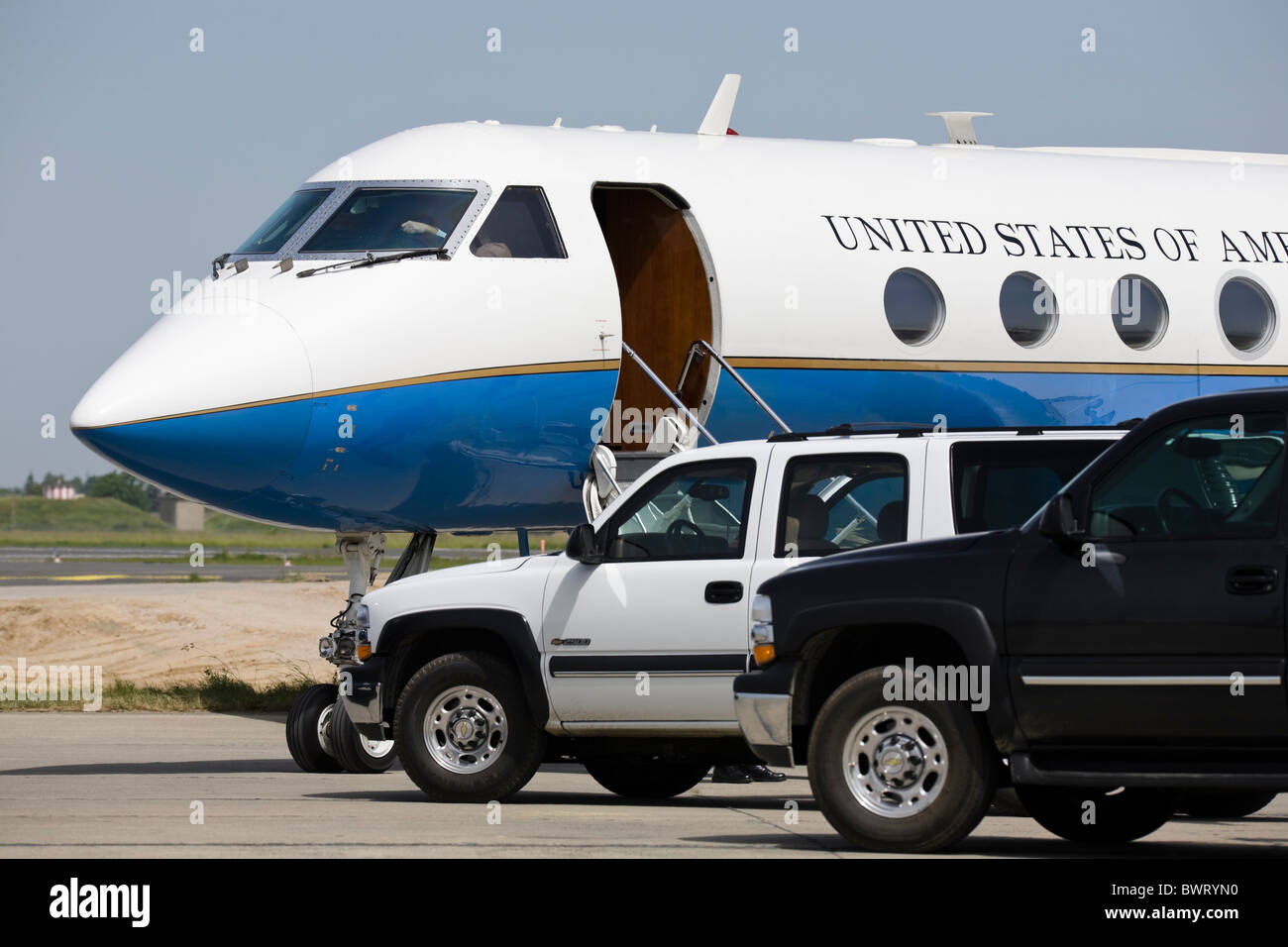 US Air Force jet Aerospace C-37A Gulfstream and cars escort waiting for a VIP at airport Stock Photo