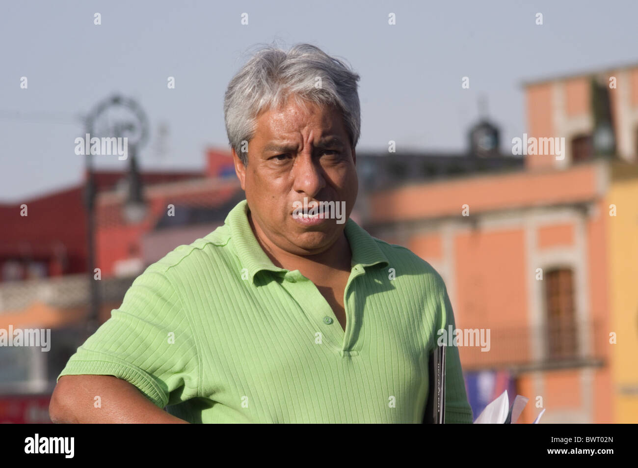 Gray haired Mexican man walking in the Zocalo of Mexico city Stock Photo