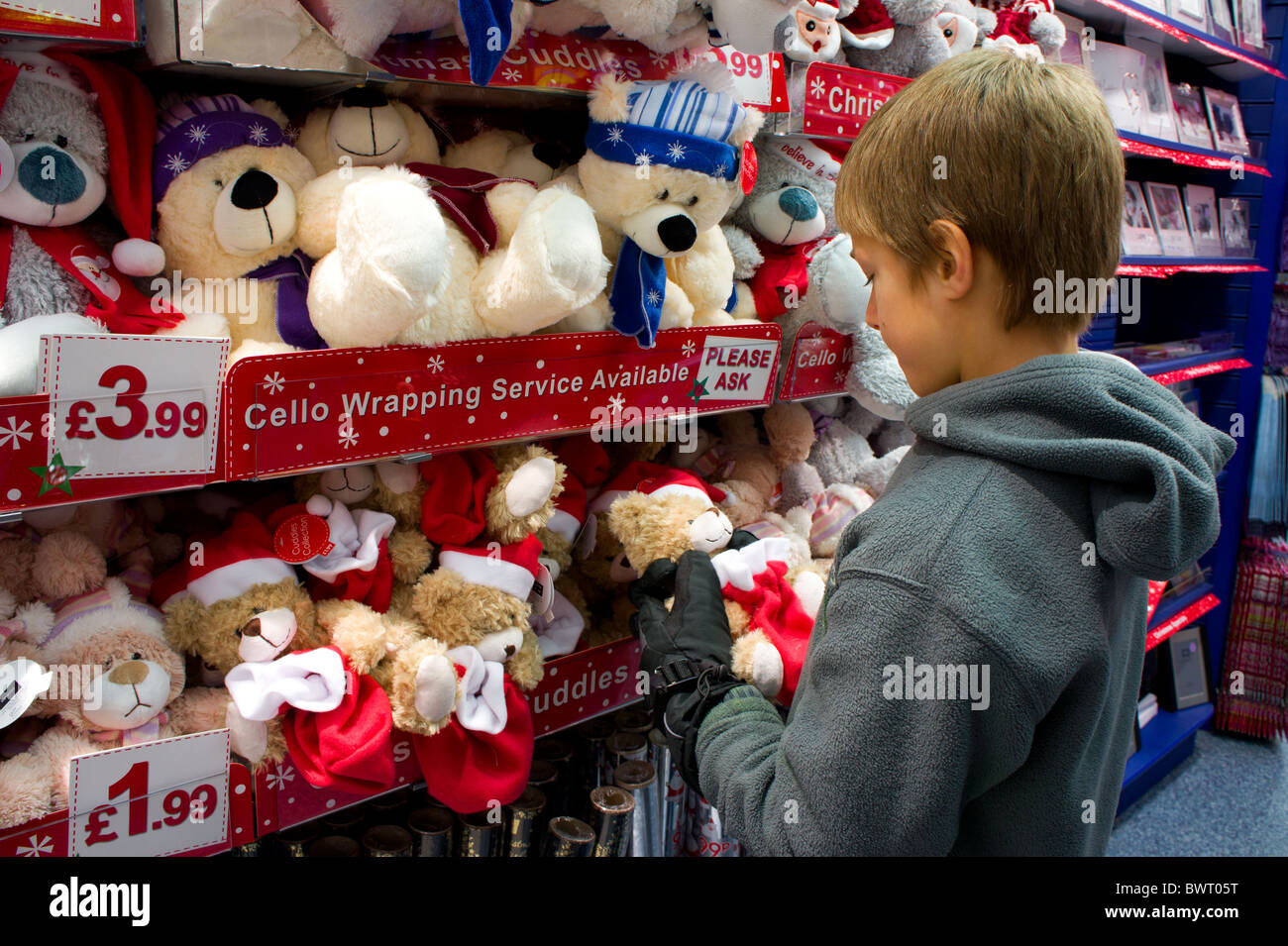 a young boy looking at christmas teddy bears in a gift shop Stock Photo