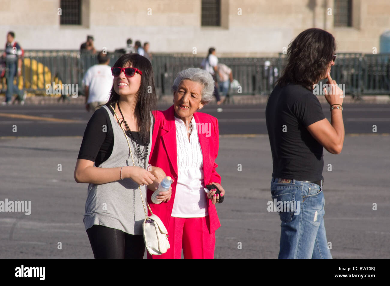 Young Mexican tourist walking with her grandmother in the Zocalo of Mexico city Stock Photo