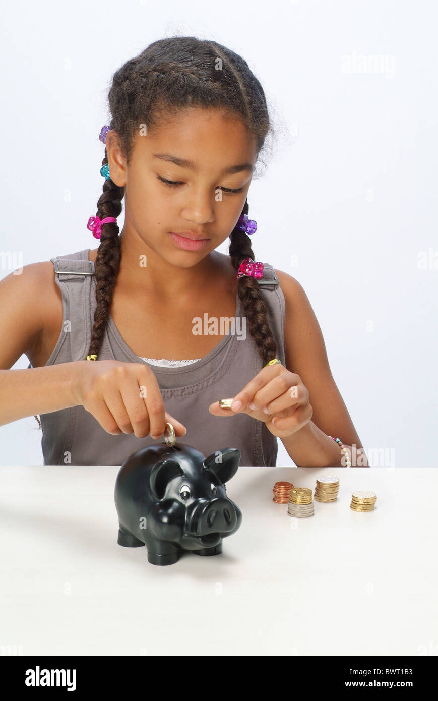 A girl with her savings and a piggy bank Stock Photo - Alamy
