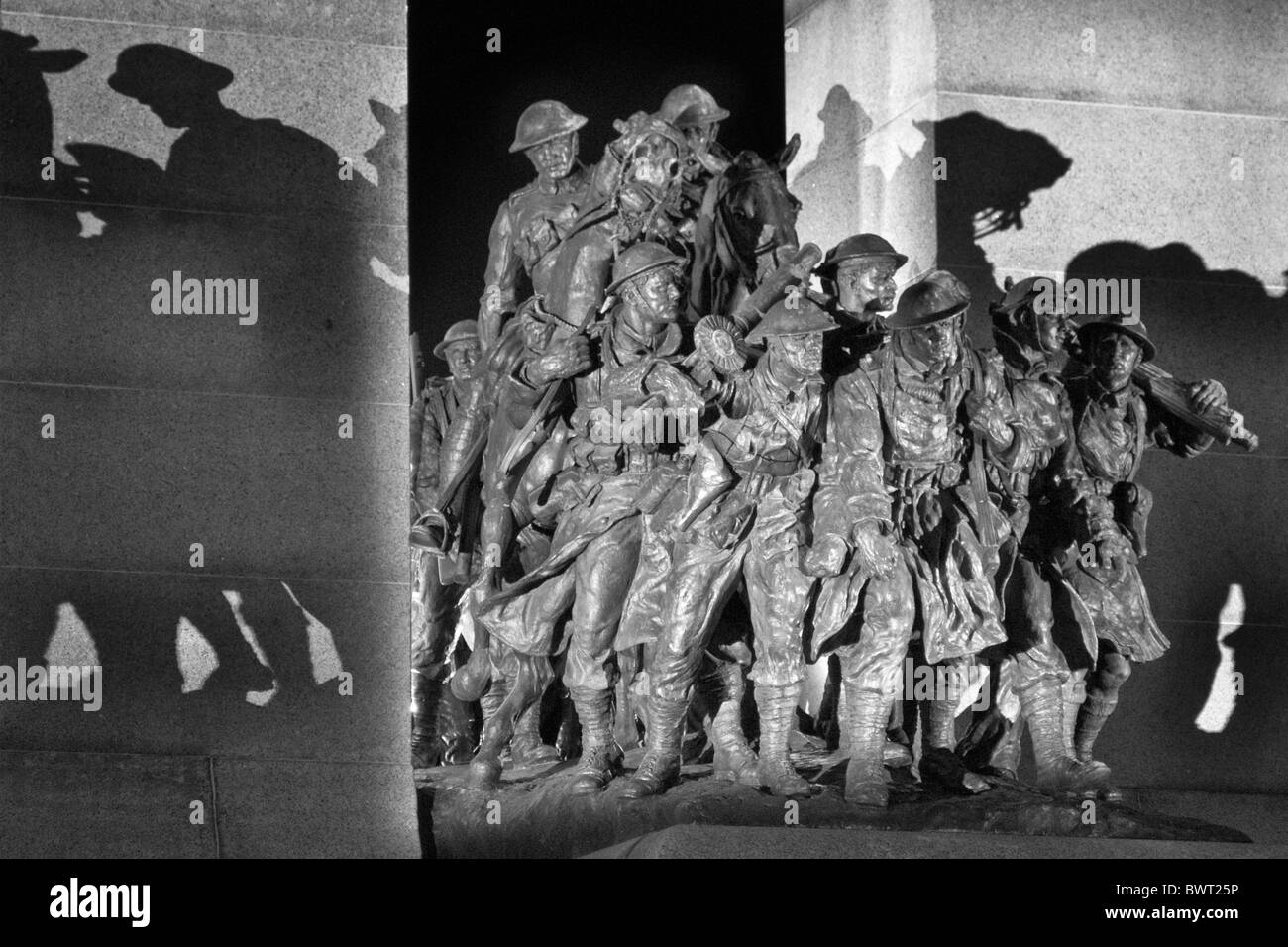 The lights on the Ottawa War Memorial cast shadows of the sculpted figures onto their surround Stock Photo
