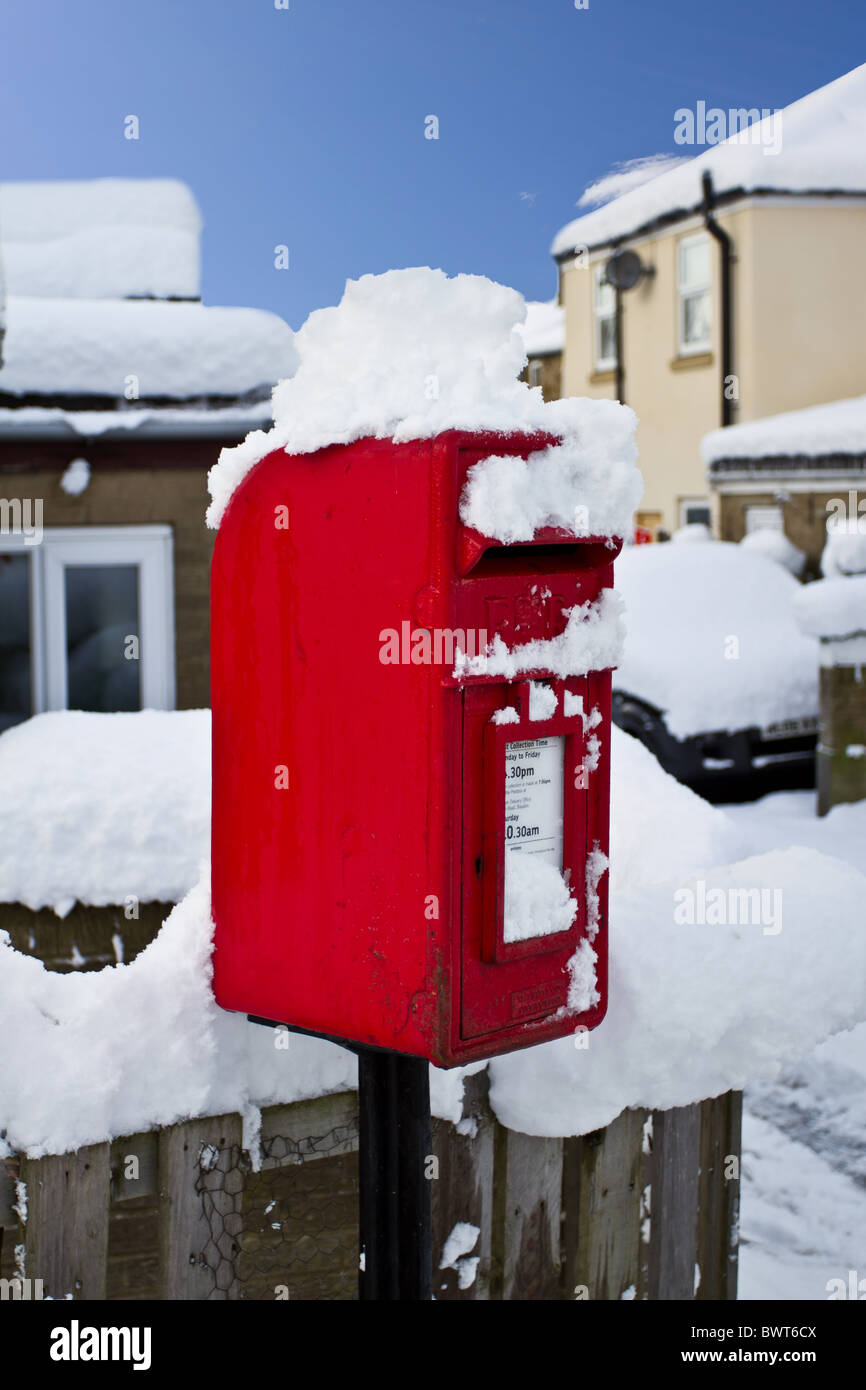 Picturesque winter scenic of thick covering of snow and red post box ...
