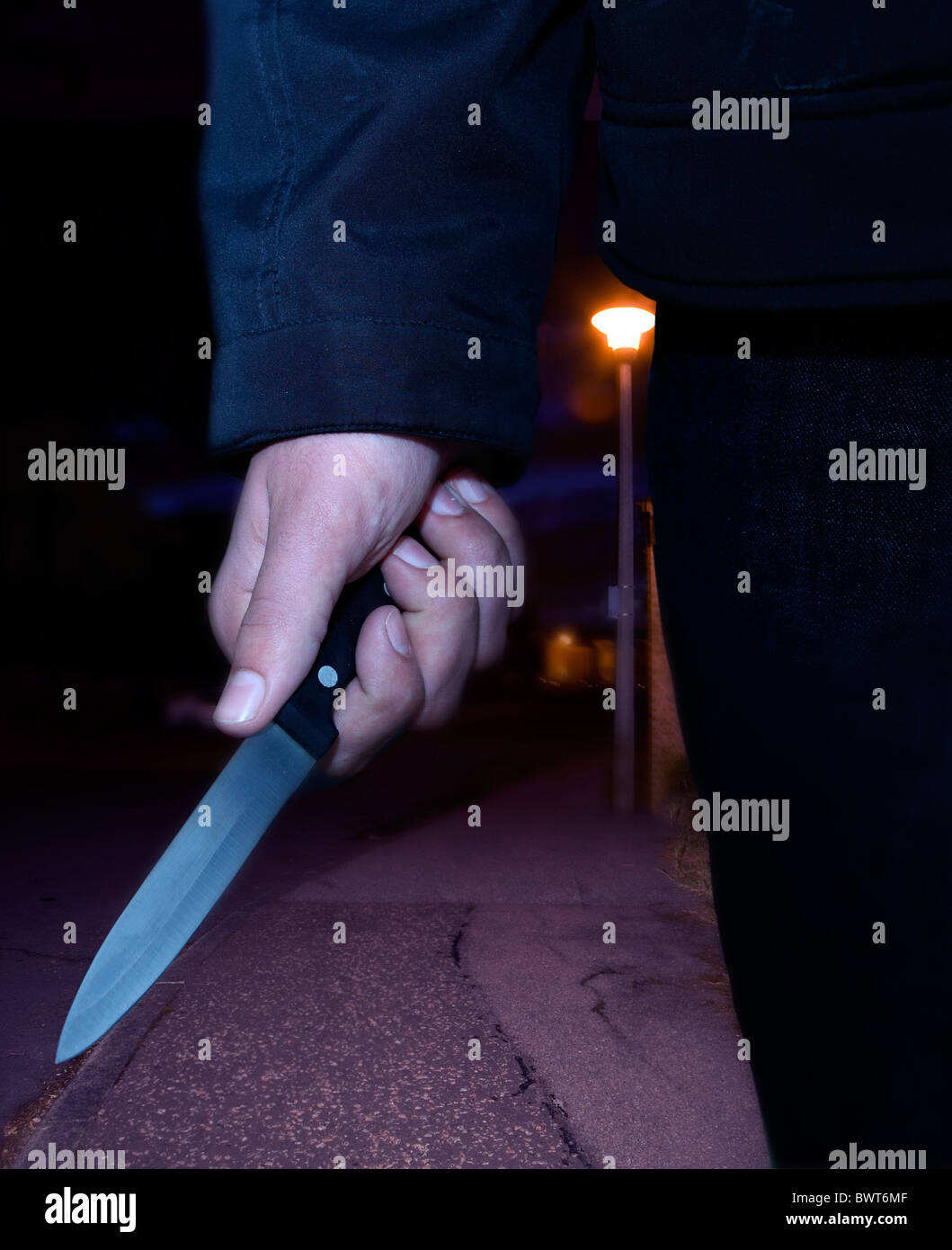 Close up of a male hand carrying a knife at night Stock Photo