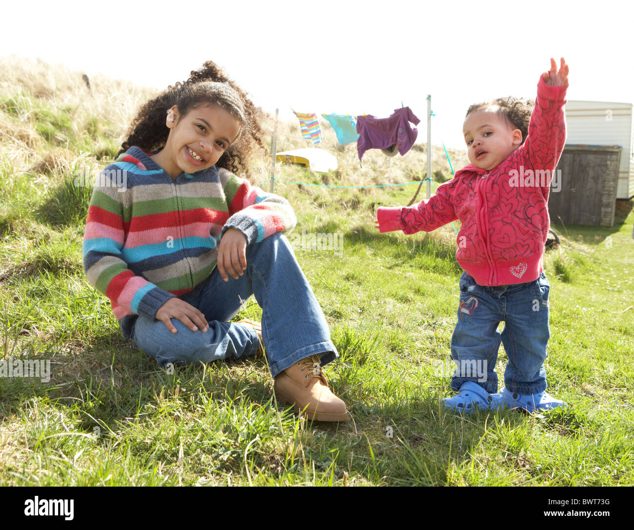 Young Girls Sitting Outside In Caravan Park Stock Photo