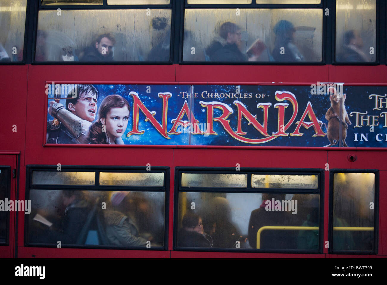 London bus passengers endure the misery of another morning commute into the city unaware of Narnia movie poster. Stock Photo