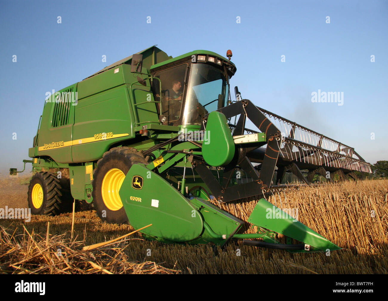 John Deer Combine harvester cutting the crop in a field in Essex Stock Photo