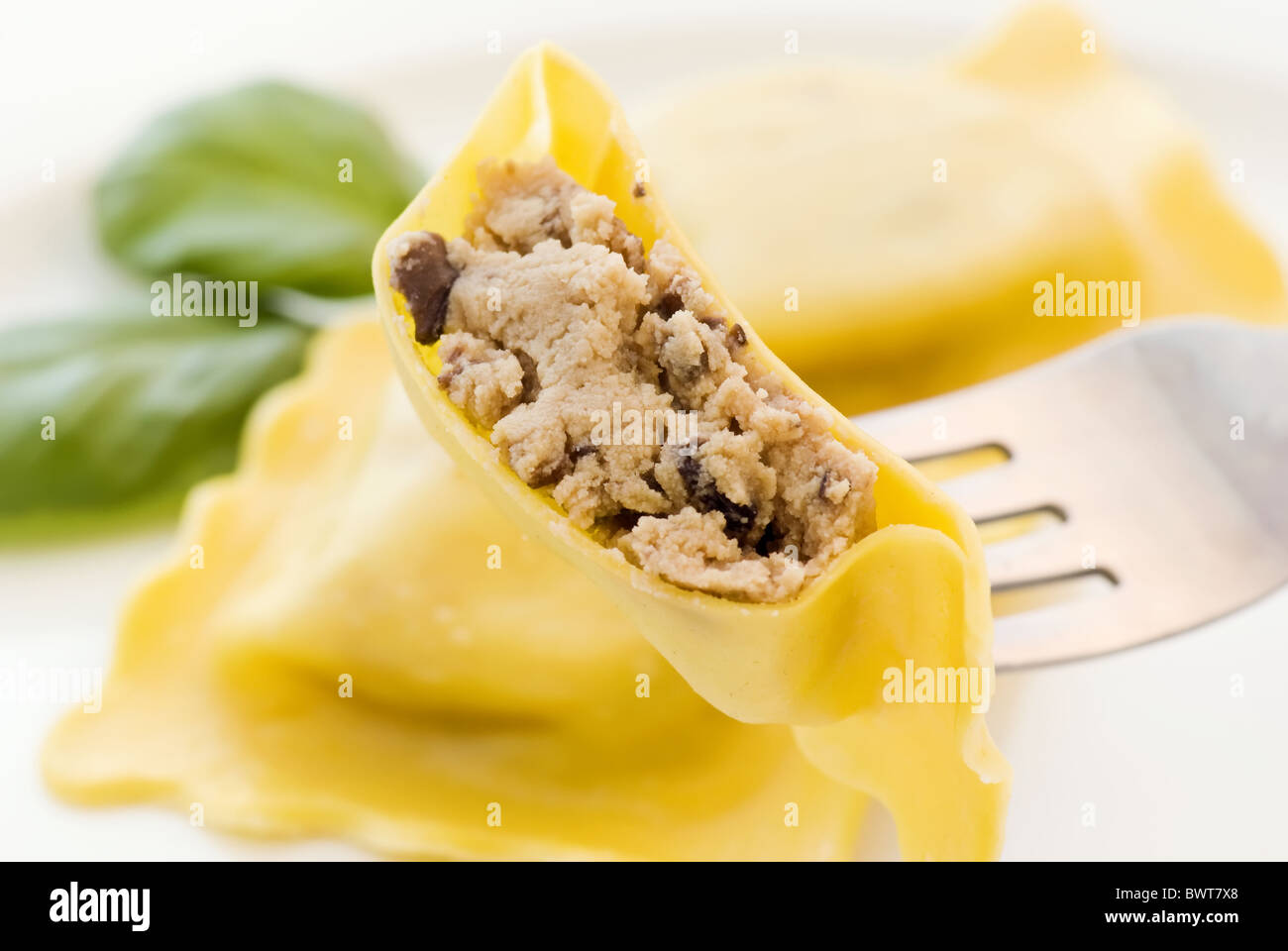 Boiled ravioli on fork as closeup on a white plate Stock Photo
