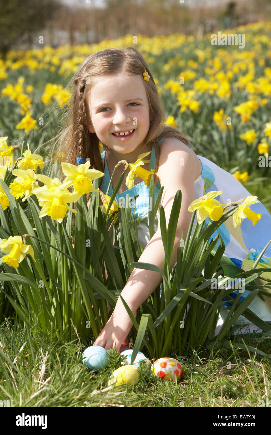 Girl On Easter Egg Hunt In Daffodil Field Stock Photo