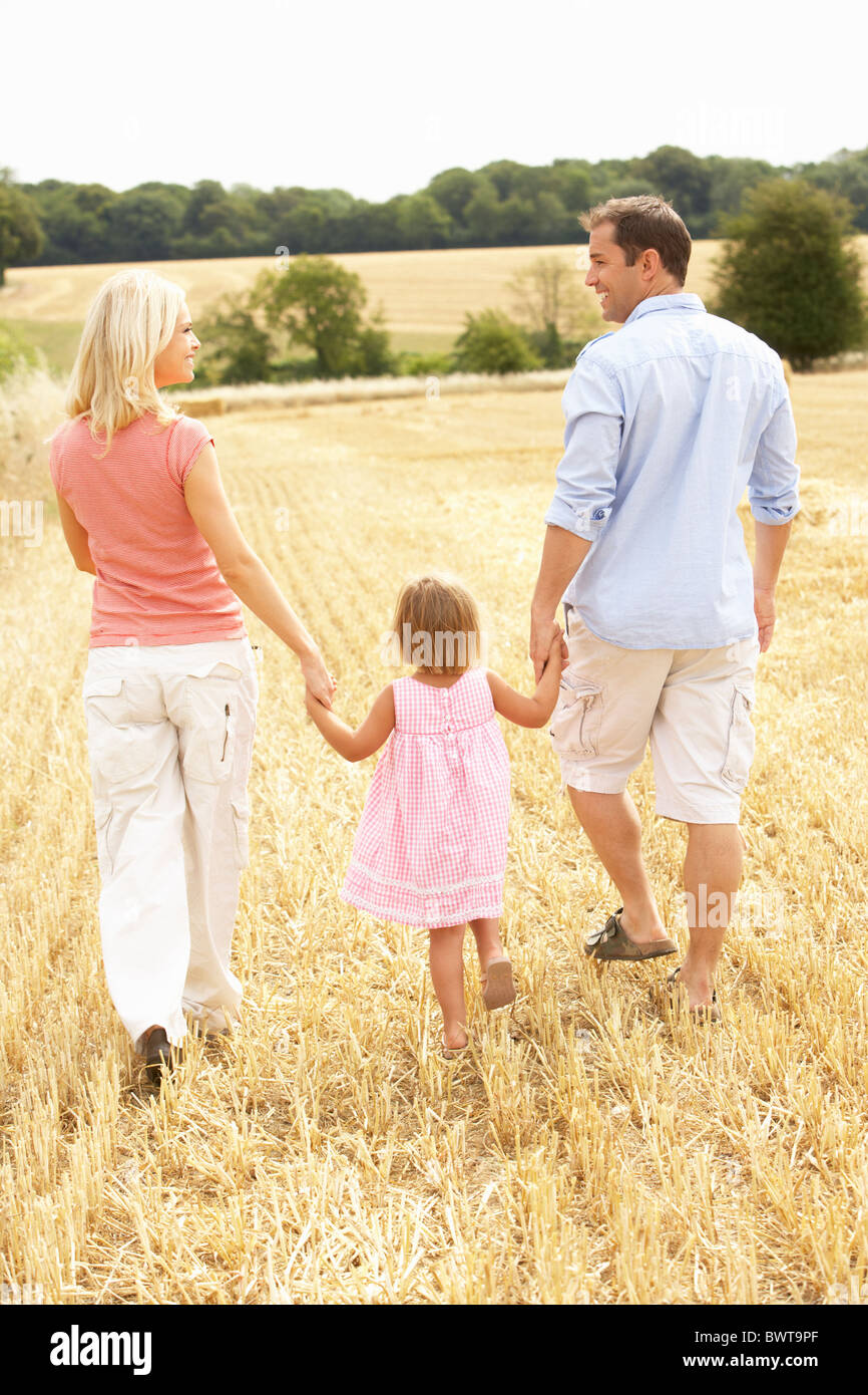 Family Walking Together Through Summer Harvested Field Stock Photo