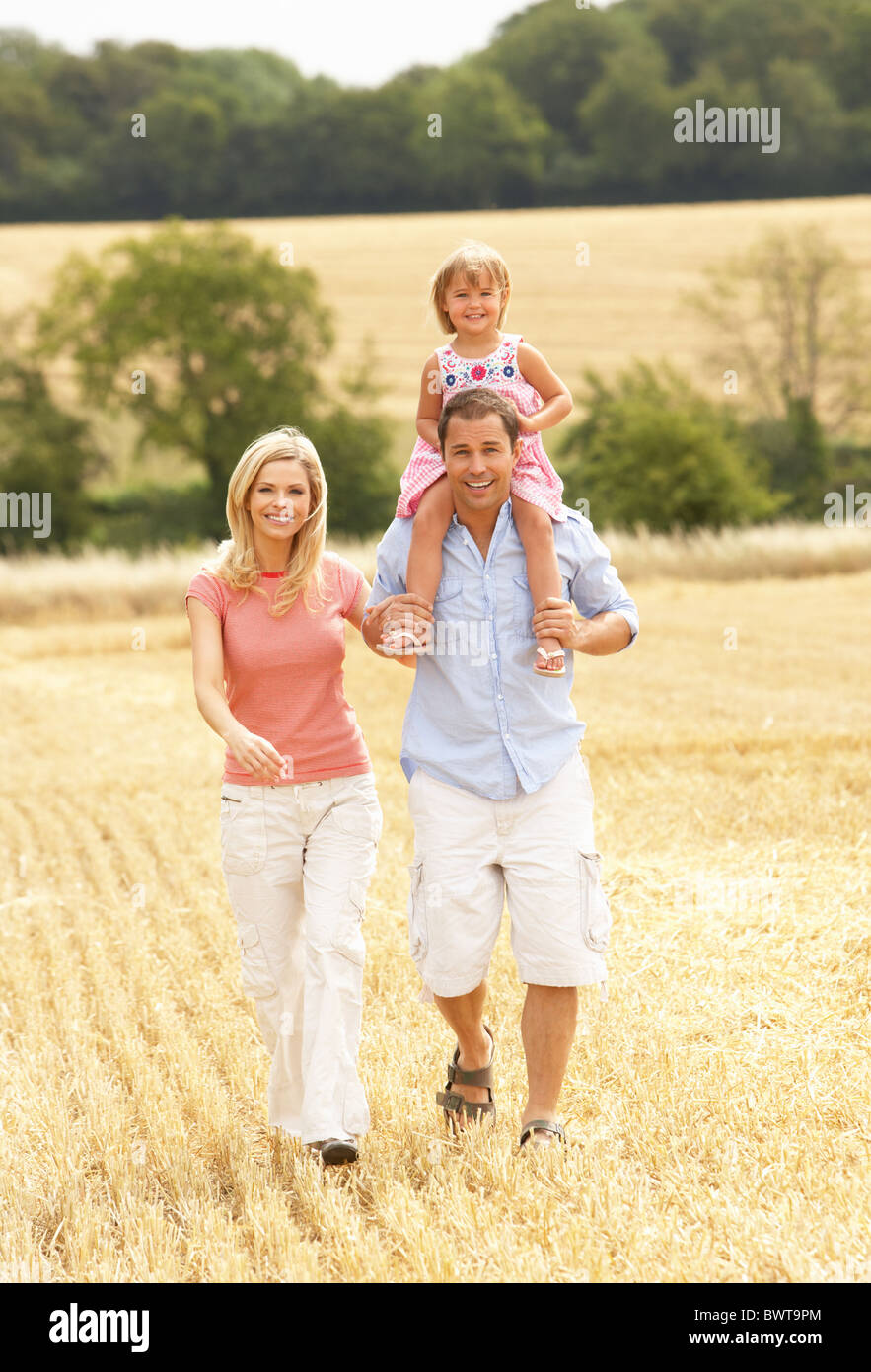 Family Walking Together Through Summer Harvested Field Stock Photo