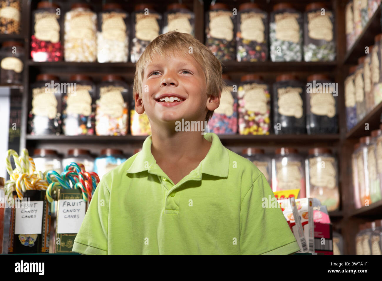Excited Boy Standing In Sweet Shop Stock Photo