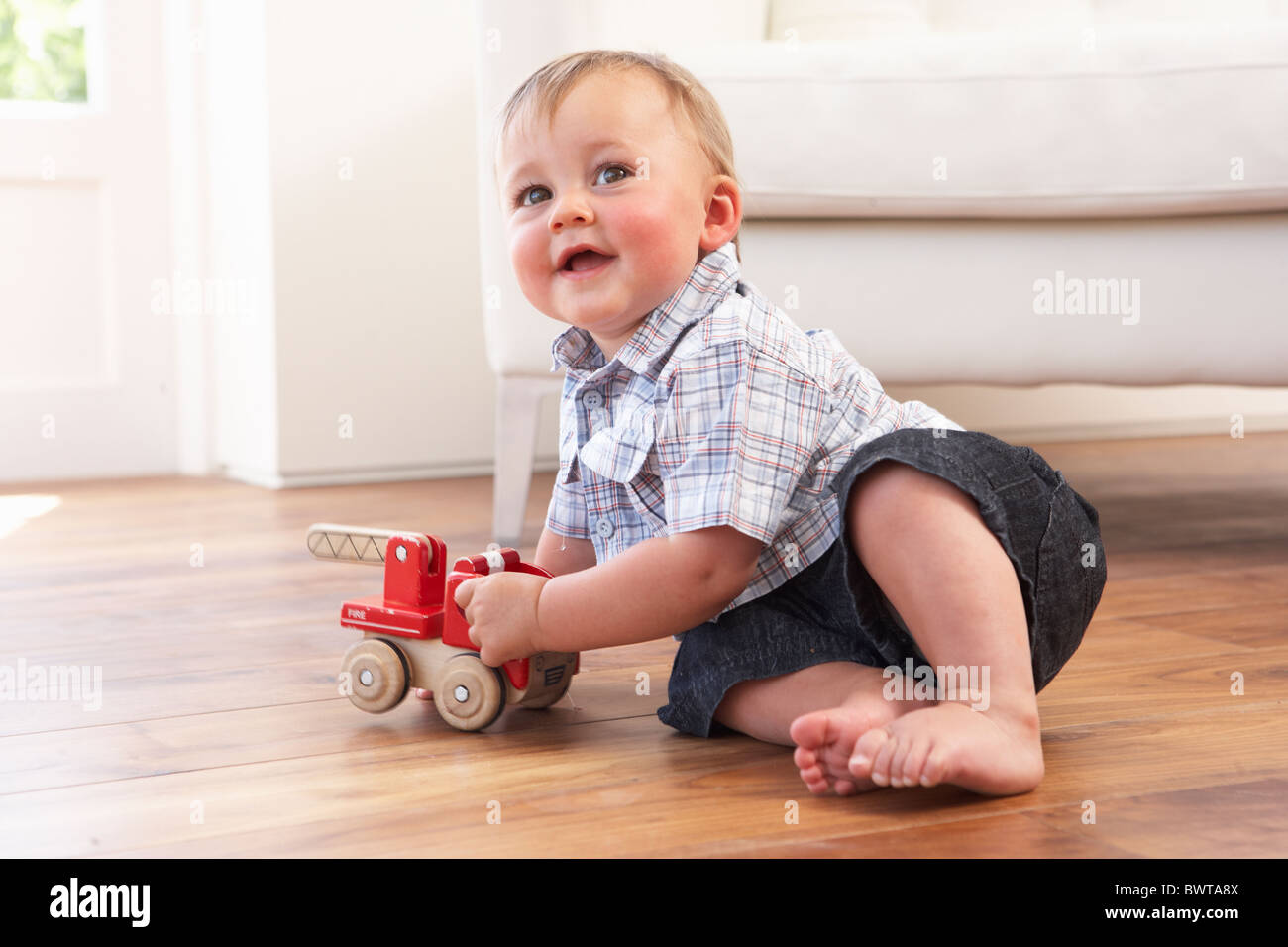 Young Boy Playing With Wooden Toy Car At Home Stock Photo - Alamy