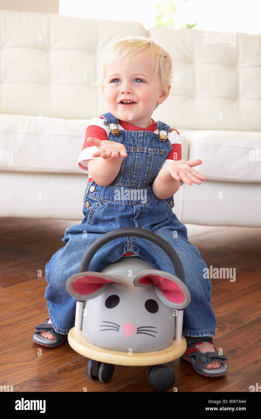 Young Boy Playing With Ride On Toy Mouse At Home Stock Photo