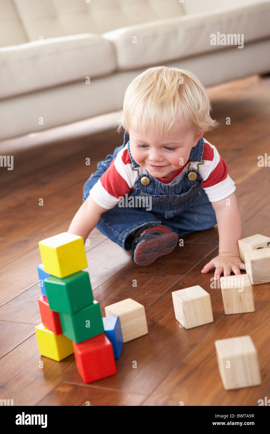 Young Boy Playing With Coloured Blocks At Home Stock Photo