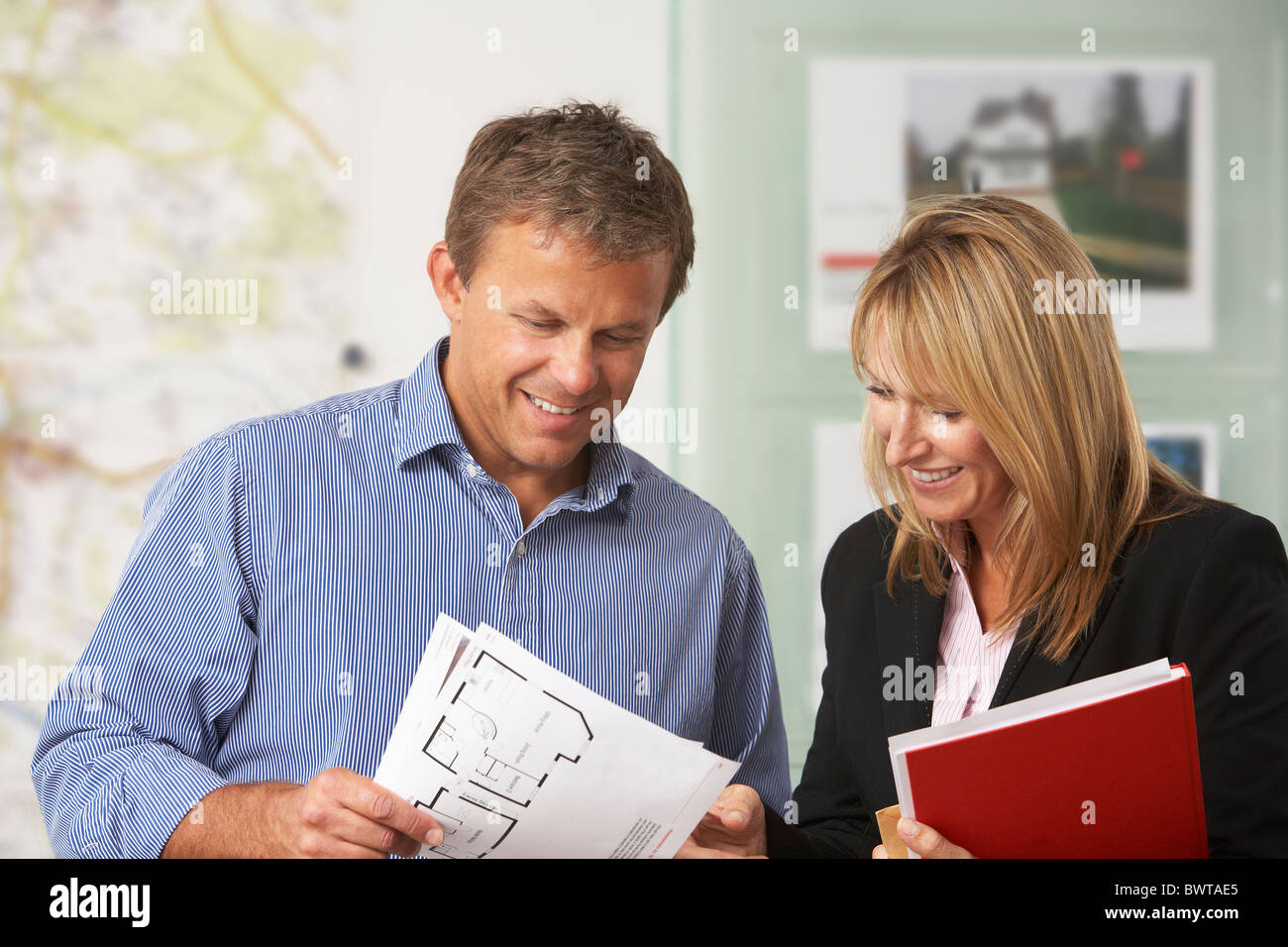 Female Estate Discussing Property Details With Client Stock Photo