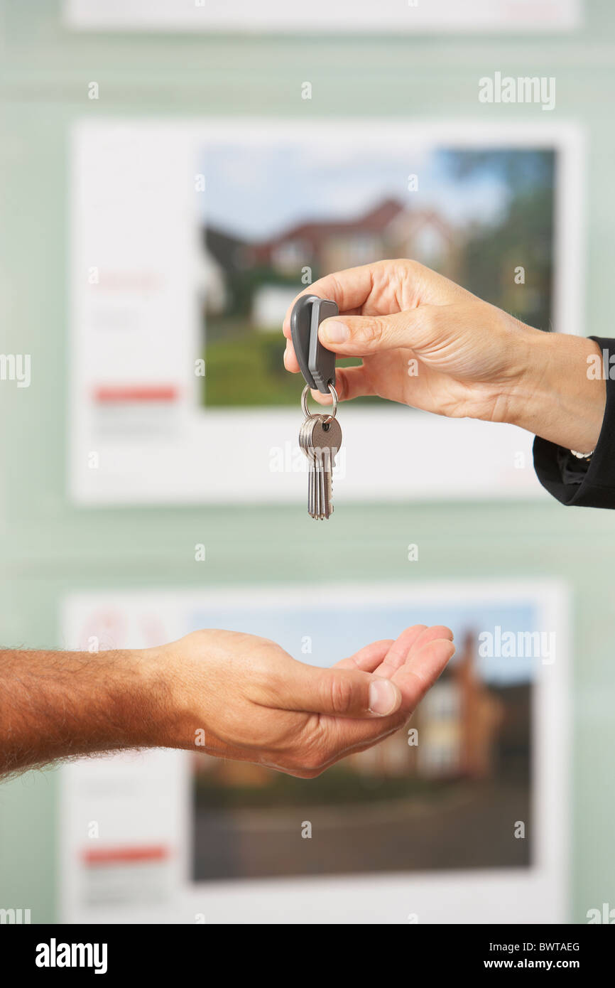 Close Up Of Estate Handing Over Keys Of New Home To Client Stock Photo