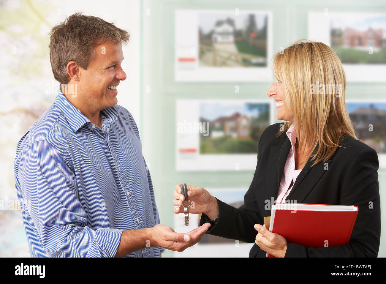 Female Estate Handing Over Keys Of New Home To Client Stock Photo