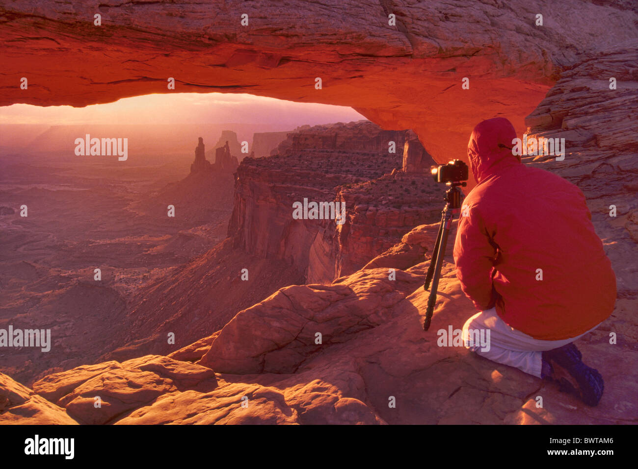 Photographer at Mesa Arch at sunrise, Island In The Sky District in Canyonlands National Park, Utah, USA Stock Photo