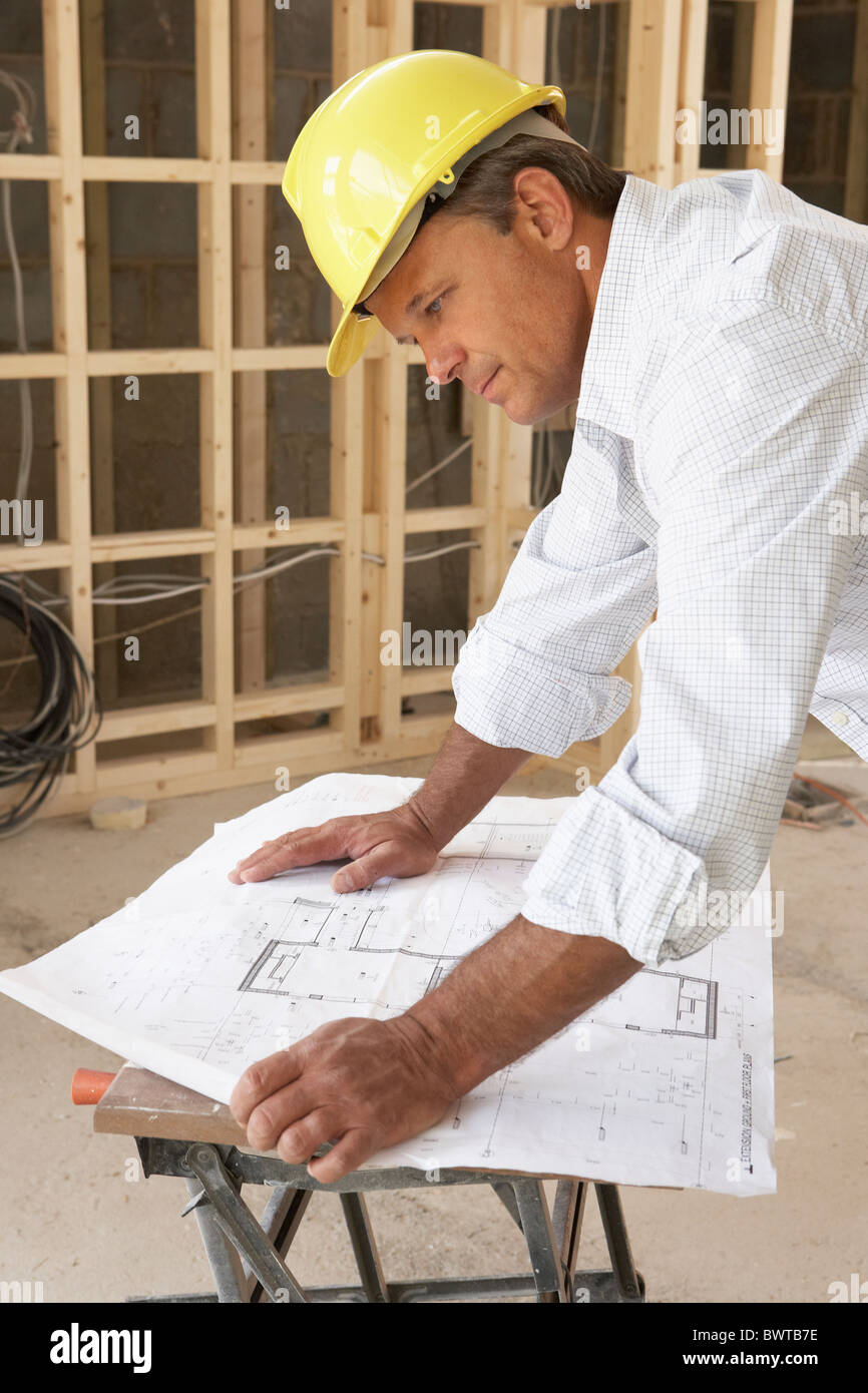 Architect Studying Plans In New Home Stock Photo