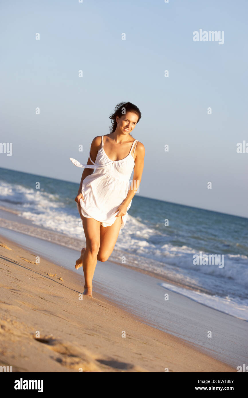 Young Woman Running Along Summer Beach Stock Photo - Alamy