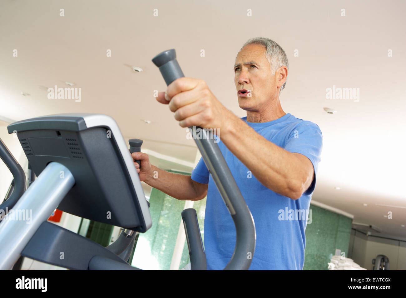 Senior Man On Cross Trainer In Gym Stock Photo Alamy
