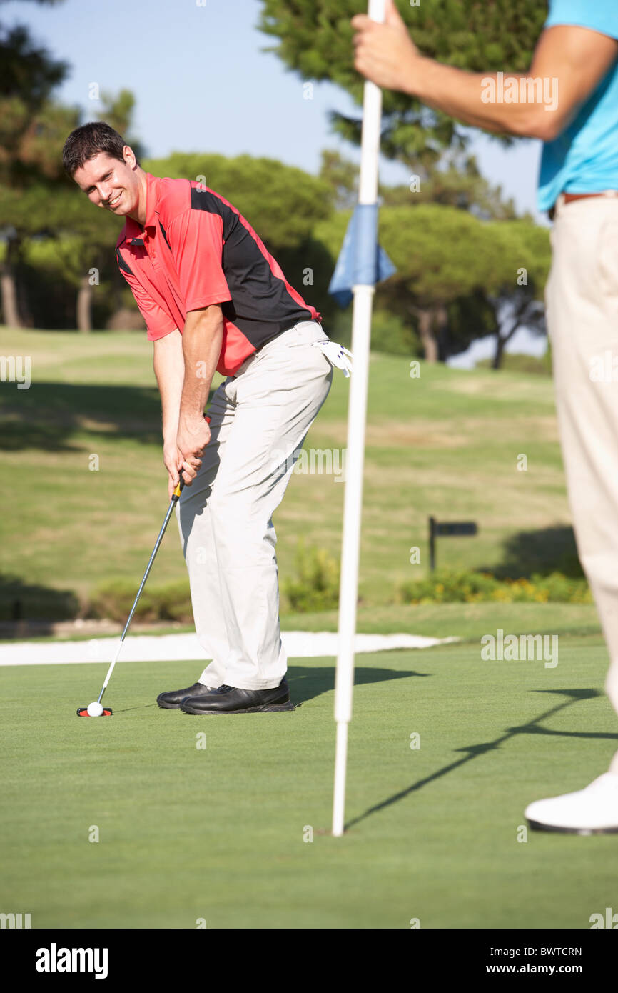 Male Golfer On Golf Course Putting On Green Stock Photo