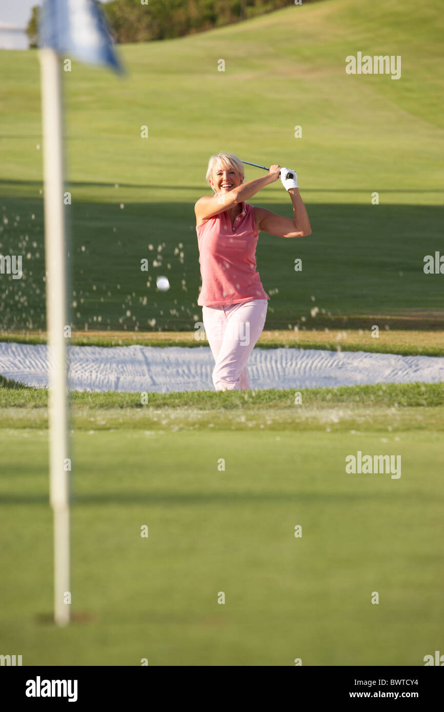 Senior Female Golfer Bunker Shot Golf Course Stock Photo