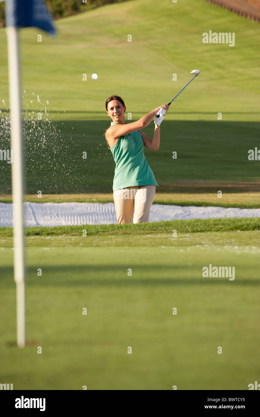Male Golfer Playing Bunker Shot On Golf Course Stock Photo
