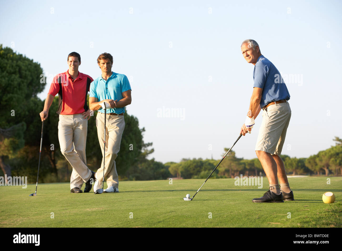 Group, Male Golfers Teeing,f On Golf Course Stock Photo