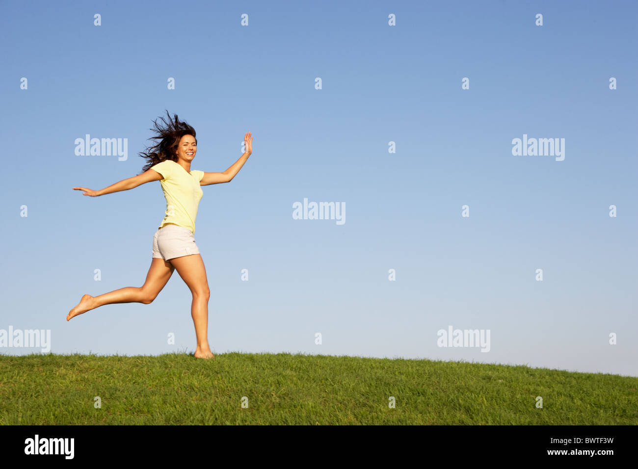 Young woman running through field Stock Photo Alamy