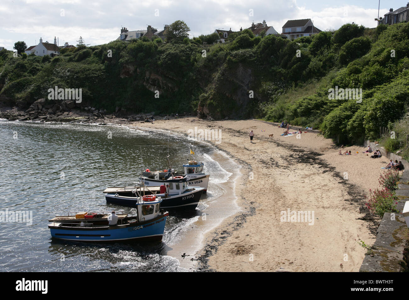 Fishing boats waiting on the tide to enter Crail harbour Fife Scotland