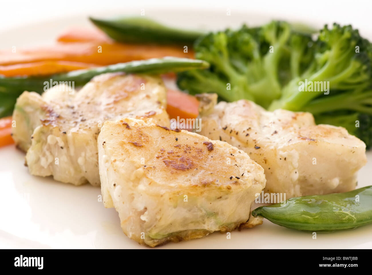 Red snapper filets with vegetable as closeup on a white plate Stock Photo