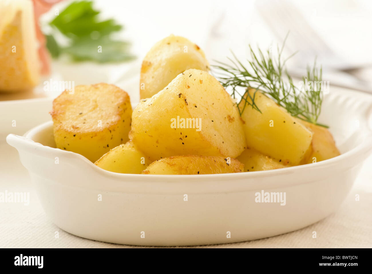 Roasted potatoes with rock melon as closeup on white background Stock Photo