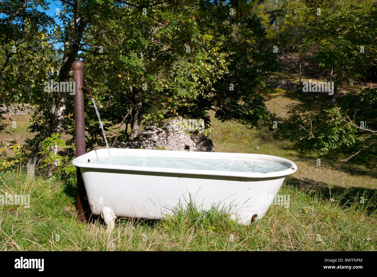 https://c8.alamy.com/comp/BWTNFM/bathtub-placed-in-countryside-and-used-as-spring-water-trough-exilles-BWTNFM.jpg