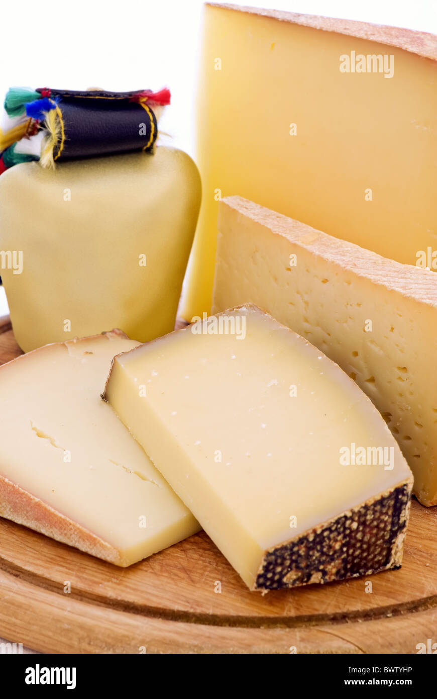 Mountain cheese collection with cowbell as closeup on a chopping board Stock Photo