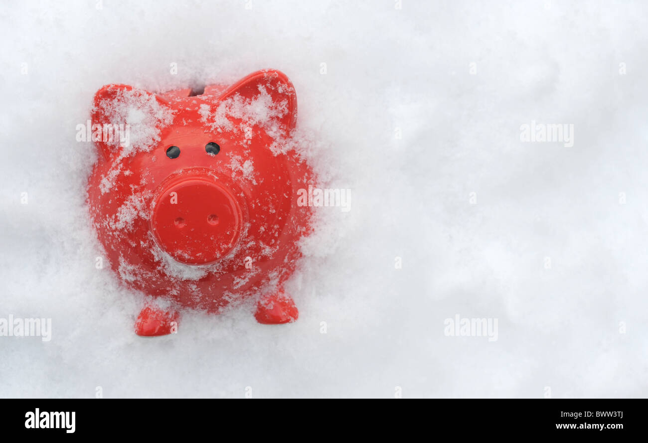 PIGGYBANK IN  WINTER SNOWY FROZEN CONDITIONS RE SAVINGS CASH MONEY MARKETS WINTER FUEL PAYMENTS ETC Stock Photo