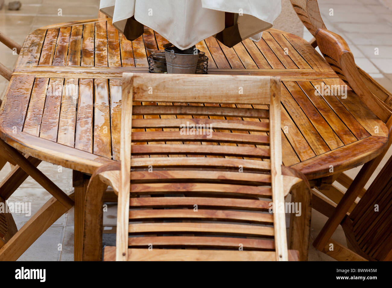 Rain covered teak table and chairs Stock Photo Alamy