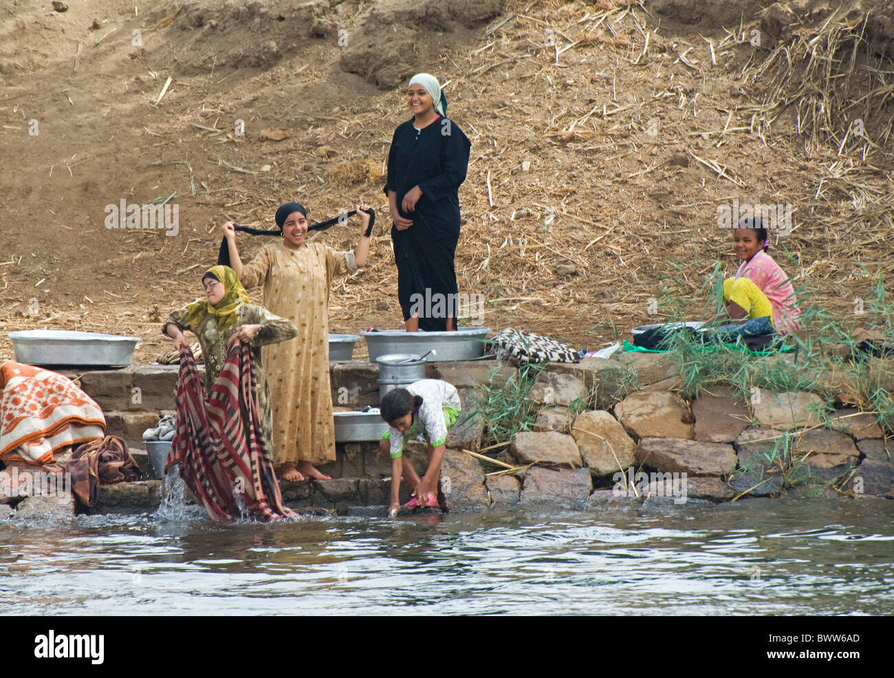 Women children washing clothes pans river River Stock Photo Alamy