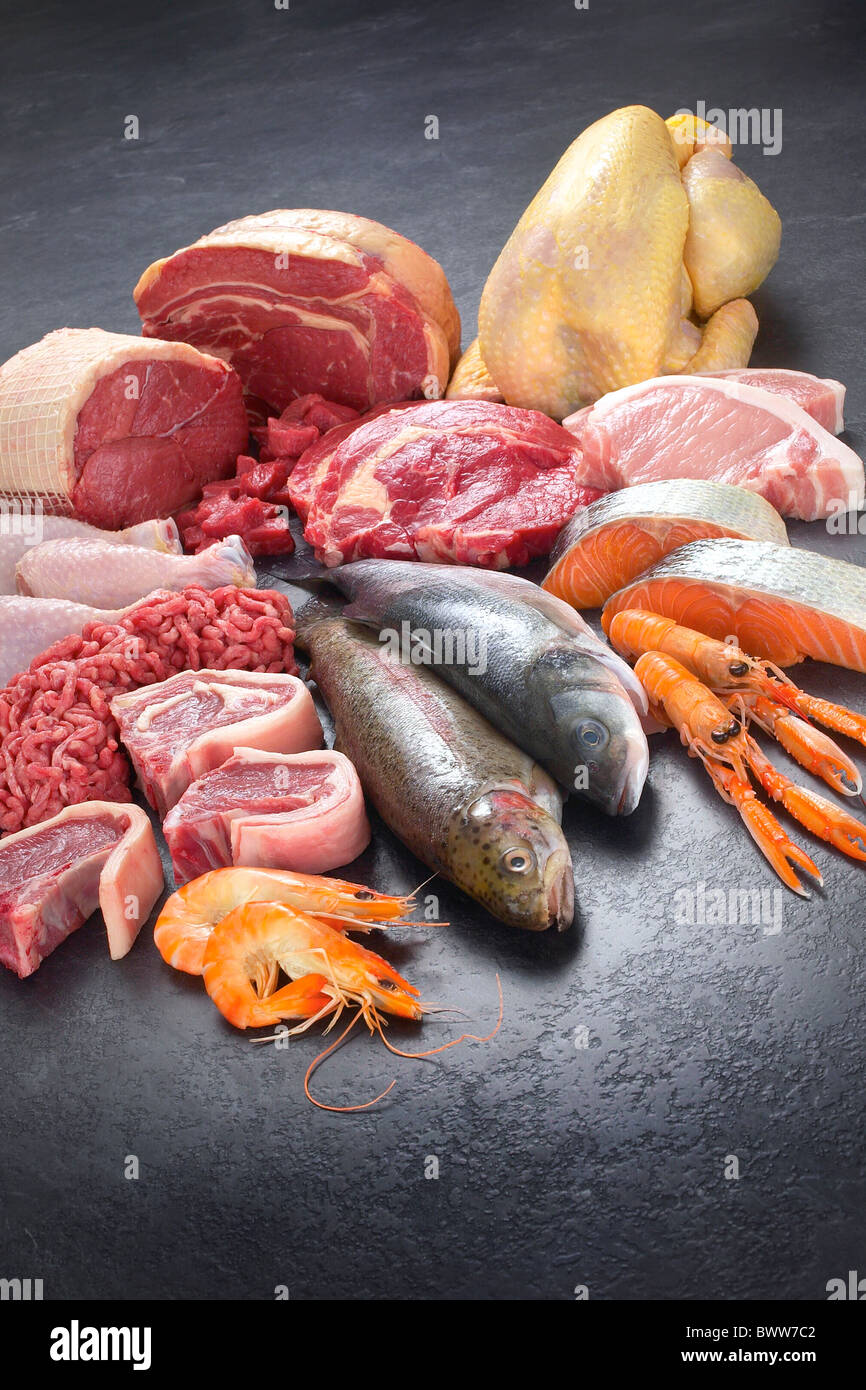 Raw meat, fish and poultry selection on dark grey background Stock